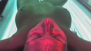 Eine Brünette genießt die Sonnenbank