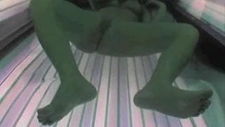 Die Schlampe befriedigt sich in der Sonnenbank