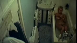 Diese Frau zeiht sich in der Badewanne aus.