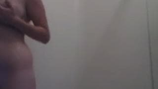 Brünette seift ihren Körper beim Duschen ein