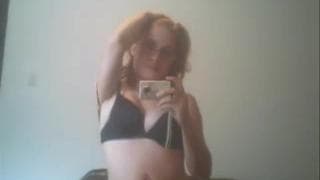 Rothaarige zieht sich bis zu ihren Dessous aus