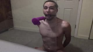 Dude mit einem Knebel Ball deepthroats seinen Dildo.