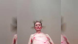 Alter schwuler Mann, der sich rot anmalt und tanzt